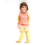 AN ARMAND MARSEILLE BISQUE SOCKET-HEAD DOLL with a cropped brown wig, sleeping brown glass eyes, and