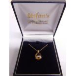 A CITRINE AND DIAMOND PENDANT stamped '14K' and '585', the facetted oval stone with a hand of