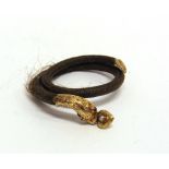 A VICTORIAN HAIR SERPENT BANGLE the head set with garnet eyes, locket back heart drop to its mouth