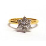 A SEVEN STONE DIAMOND CLUSTER RING stamped 'Platinum 18ct', the brilliant cuts totalling