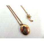 A VICTORIAN OVAL LOCKET the pearl starburst centre in gilt metal, on a chain; with an Edwardian