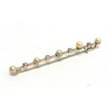 A DIAMOND AND PEARL BAR BROOCH stamped 'Plat & 18ct W.G.D.', the five pearls alternate set with four