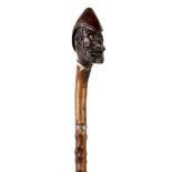 ANGLO-ZULU WAR 1879 - AN UNUSUAL CARVED WALKING CANE  the grip modelled as the head of a moustached,