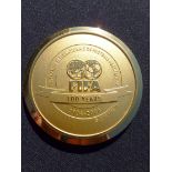 Two official FIFA medals, i) an official medal struck to commemorate the centenary of FIFA 1904-