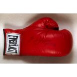 An Evander Holyfield signed boxing glove, a left-hand red Everlast glove signed in black marker pen,