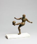 A small spelter figure of a footballer, bronze patina, modelled volleying the ball, set on a