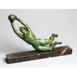 A spelter figure of a diving goalkeeper, with green patina, set on a marble plinth, 22 by 35cm., 8