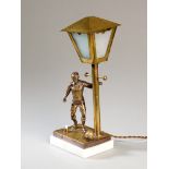 A table lamp designed with a brass footballer set on a marble base, the lamp post with detachable