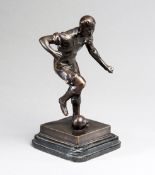 A bronze figure of a footballer,
signed J Skeaping on the base,
