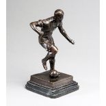 A bronze figure of a footballer,
signed J Skeaping on the base,