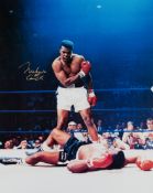 A large colour photograph of the "phantom punch" signed by Muhammad Ali,
20 by 16in.