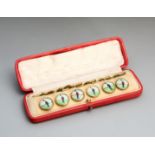 A cased set of six Edwardian gentlemen's waistcoat buttons each set with a print of a footballer,