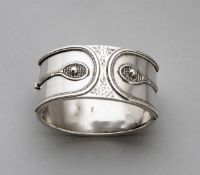 An Edwardian hallmarked silver oval bangle decorated to the front with two raised tennis rackets
