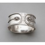 An Edwardian hallmarked silver oval bangle decorated to the front with two raised tennis rackets