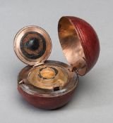 A Victorian travelling inkwell modelled as a cricket ball,
with a red leather covering,