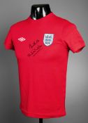 A red England t-shirt signed by Bobby and Jack Charlton,