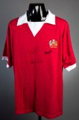 A Manchester United retro shirt signed by the 'United Trinity'  Bobby Charlton,
