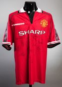A red Manchester united replica jersey signed by the 1998-99 Treble Winners,
