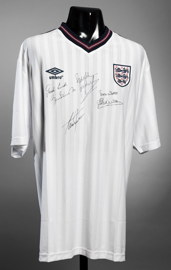 A white England replica jersey signed by four prolific goalscorers Bobby Charlton, Gary Lineker,
