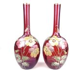 A pair of florally enamelled Cranberry glass vases, late 19th/early 20th century.