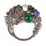 Silver multi gem brooch. Of foliate design and set with multi gem cabochons. Diameter 45 mm.