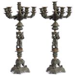 Coppia di candelabri in metallo a sei luci, fusti decorati con figure antropomorfe e teste