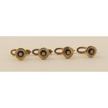 A boxed set of four shirt studs in 9ct gold with a central diamond a ring of black enamel and a ring