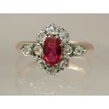 A Victorian ruby and diamond ring set with an oval cut ruby and rose cut diamonds, set in yellow and