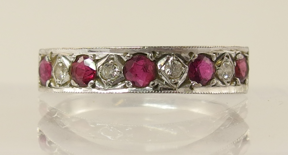 An 18ct white gold ruby and diamond half eternity ring
