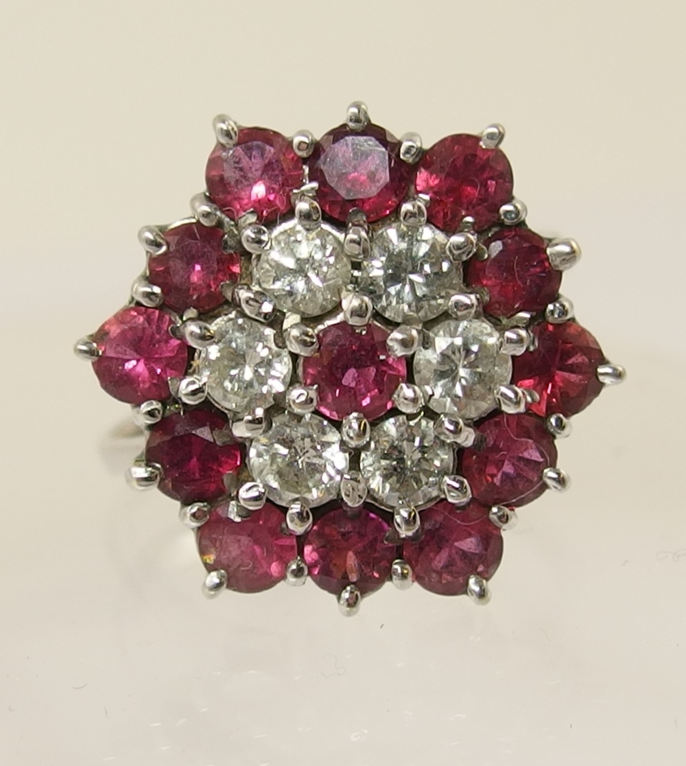 A ruby and diamond flower cluster ring. Diamond combined total approx 0.60cts