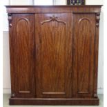 A Victorian mahogany three door wardrobe with raised mouldings flanked by acanthus leaf scroll