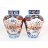 A pair of Imari baluster vases, covers and liners  painted with jardinieres of flowers and rabbits
