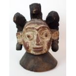 An African carved and painted wood mask with animal finial and scroll shaped ears, 38cm high