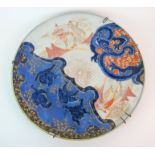 An Imari dish painted with fishermen, herons and a dragon (rim chips), signed, 50cm diameter