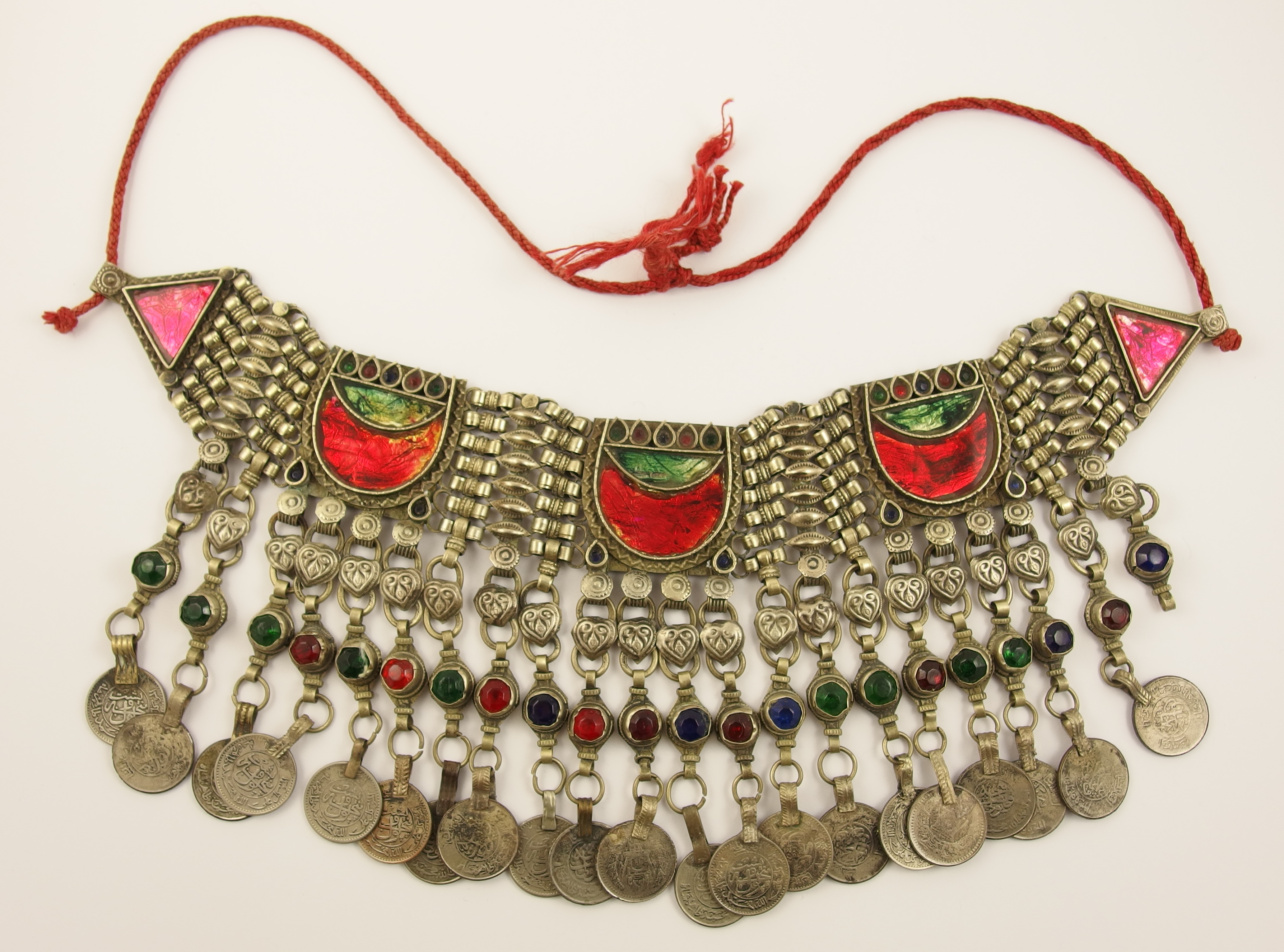 An Islamic statement necklace in white metal with foiled glazed panels, and coin pendants.