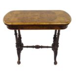 A Victorian walnut card table the rounded rectangular top above carved scroll legs joined by a