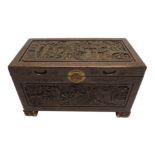 A Chinese camphorwood carved blanket chest decorated with figures in gardens within key pattern