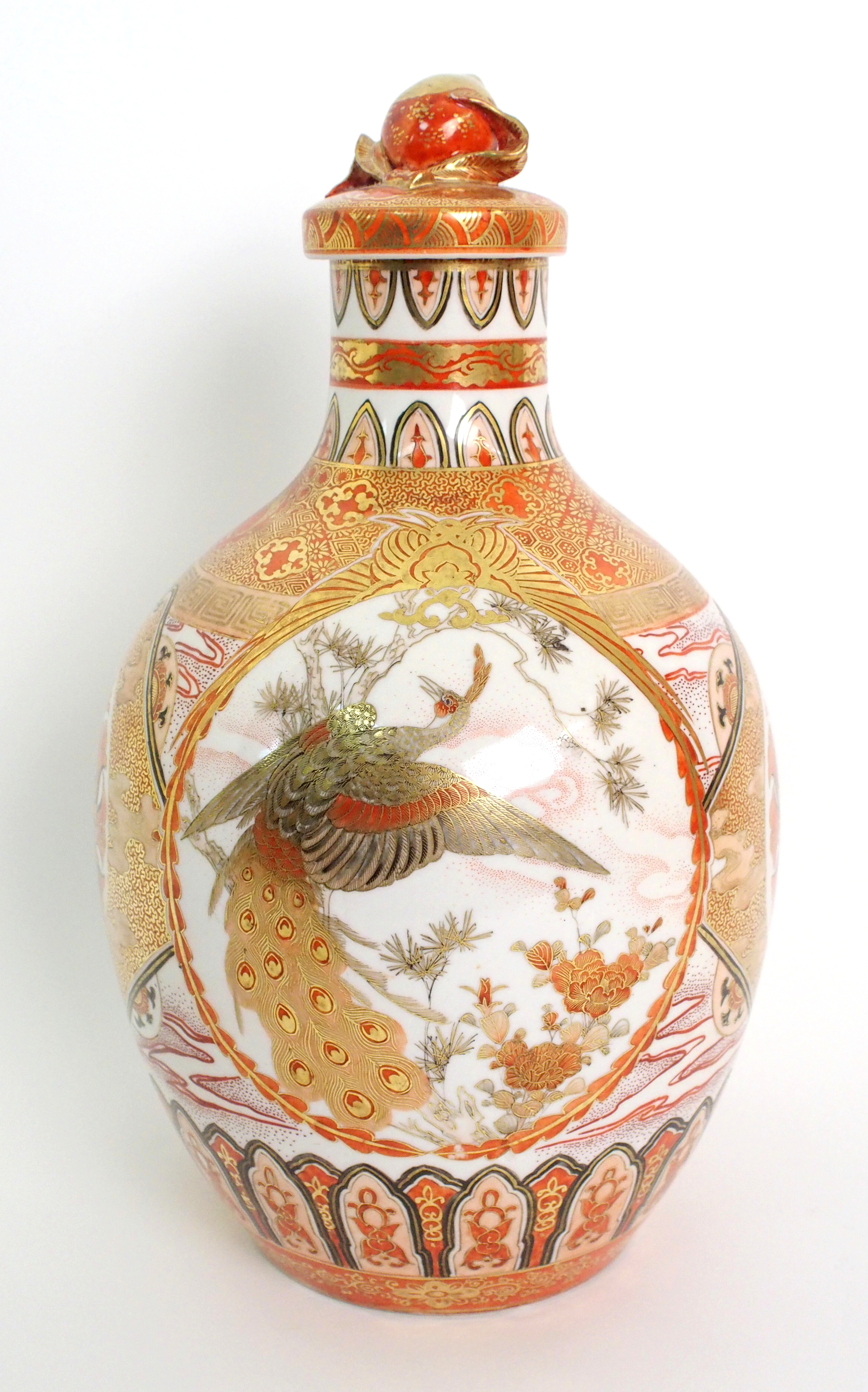 A Kutani bottle shaped vase and cover painted with medallions of figures, peacocks, pine within gilt