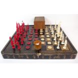 A Chinese export chess and draught set in bone and ivory with black and gold lacquered hinged board,