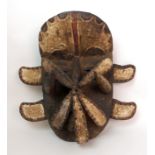 An African carved and painted wood mask with brass studded decoration, 40cm high