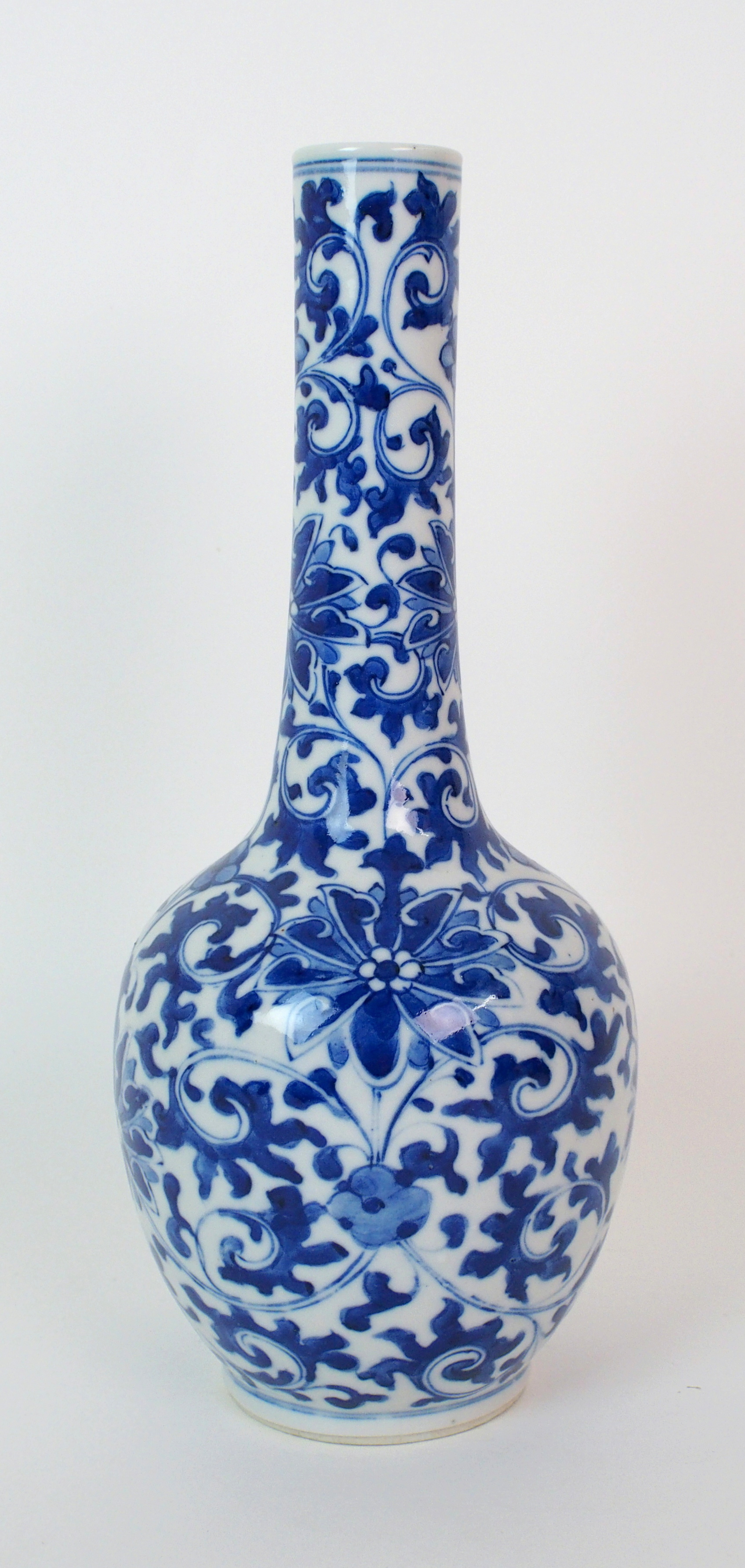 A Chinese blue and white bottle shaped vase painted with peonies and scrolling foliage, blue