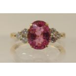 An 18ct hot pink spinel and diamond ring dimensions of the spinel 9.7mm x 7.2mm, set with three