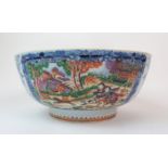 A Chinese export punch bowl painted with huntsman chasing deer within blue foliate vignettes above