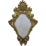 A continental gilt wood wall mirror carved with mermaids beneath a scrolling cartouche enclosing a