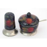 A Moorcroft Pottery Tudric "Pomegranate" mustard pot and pepper shaker circa 1920, the circular