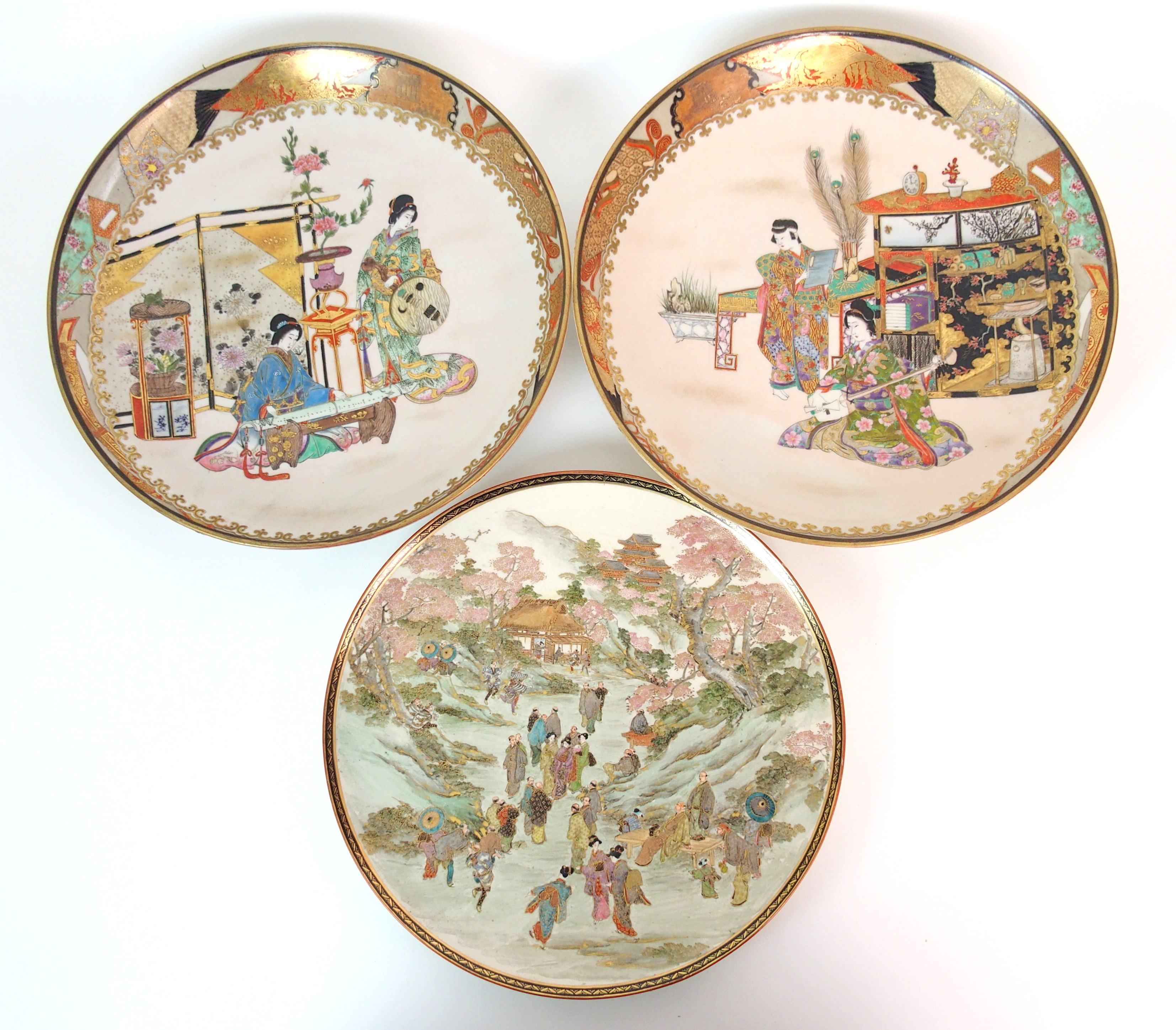 A pair of Japanese dishes painted with ladies playing musical instruments amongst precious objects