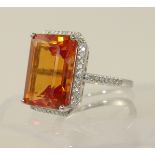 A 14ct ring set with an orange sapphire and diamonds  the emerald cut sapphire of approximately