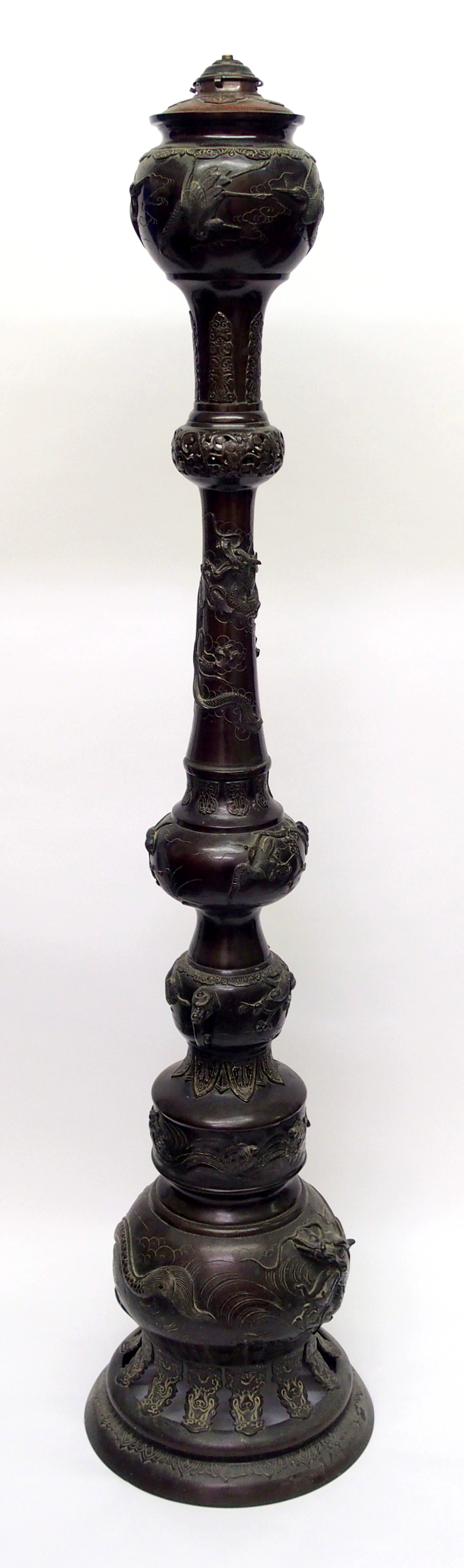 A large Japanese bronze oil lamp cast in sections with cranes, dragons, turtles, lappets, clouds and