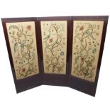 A mahogany three fold draft screen with floral crewelwork panels beneath a carved frieze, 176cm