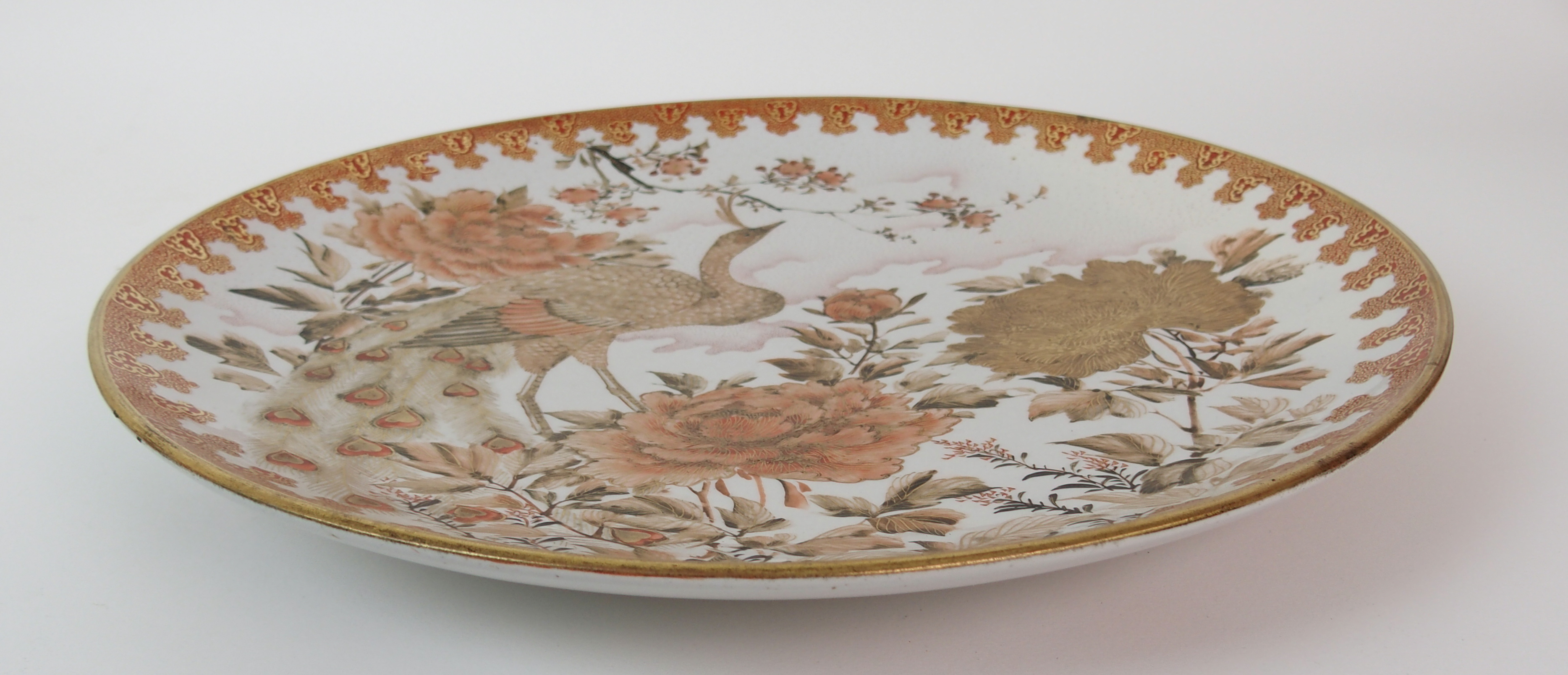 A Kutani dish painted with a peacock amongst peonies and blossoming branches within a red and gilt - Image 7 of 10